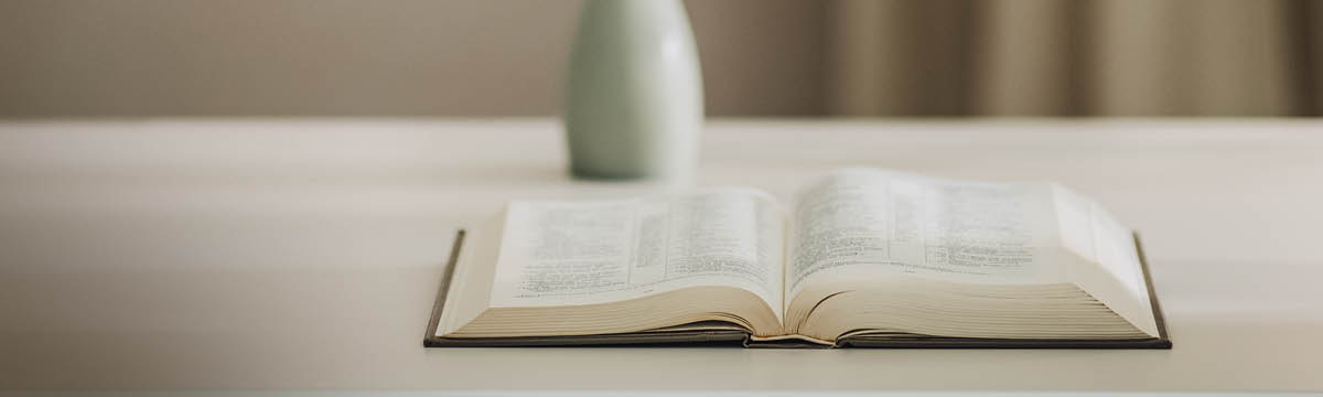 Una Bìblia verta sora una tola.