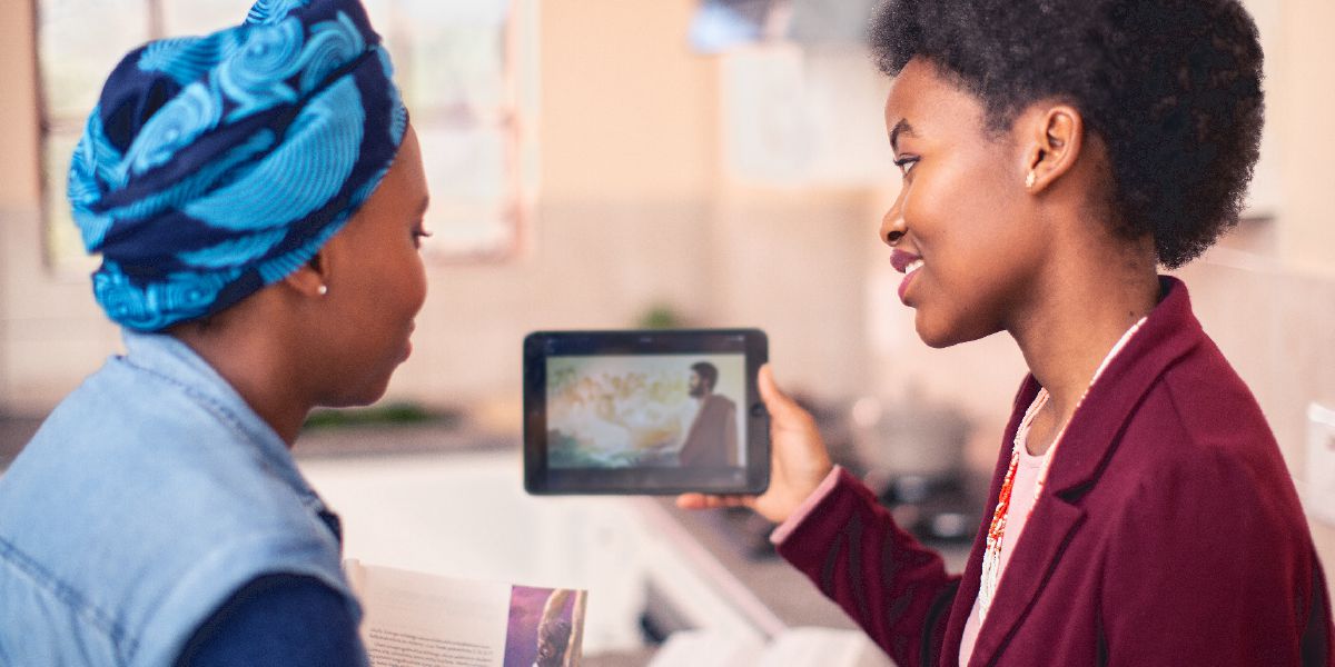 Una sorela la mostra un vìdeo a una studiante dela Bìblia