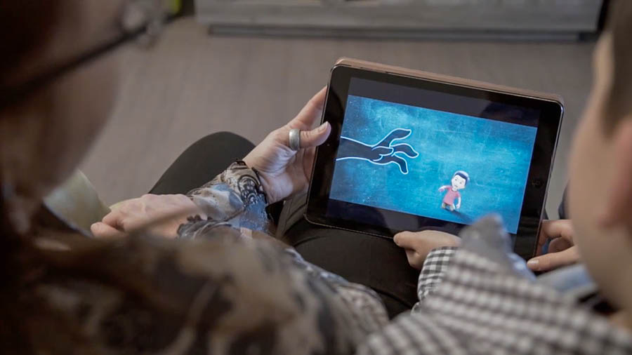 Una parte del vìdeo ‘Fà su una casa firme e forte — Gavé de proteger i to fioi dele ‘robe brute’’.Una mare e el so fiol i varda el vìdeo ‘Toca proteger i fioi.’