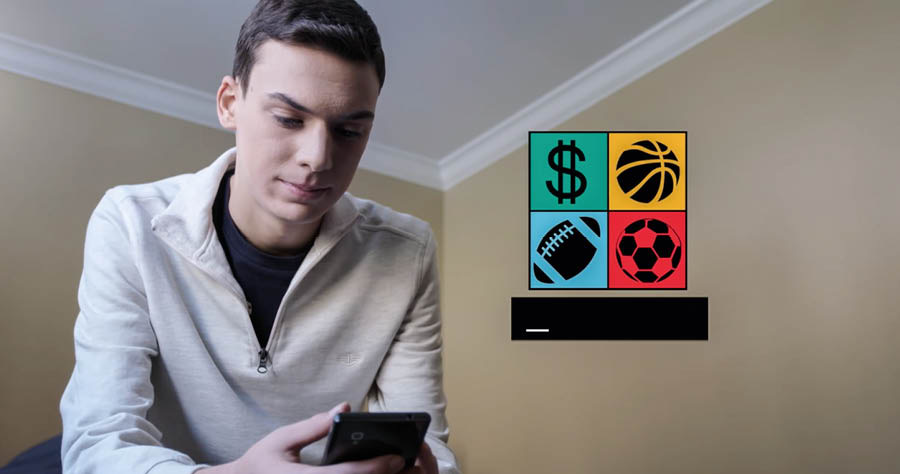 Una parte del vìdeo ‘No stà far compagno i infedeli’. Un gióveno l’è drio vardar nel selular un link de giughi nela internet par guadagnar soldi.