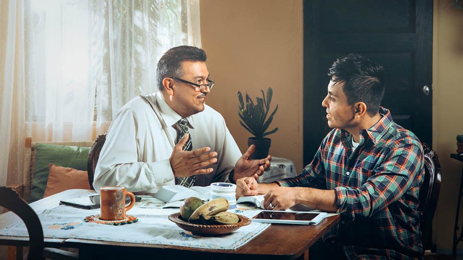 Un fradel stùdia la Bìblia con nantro omo.