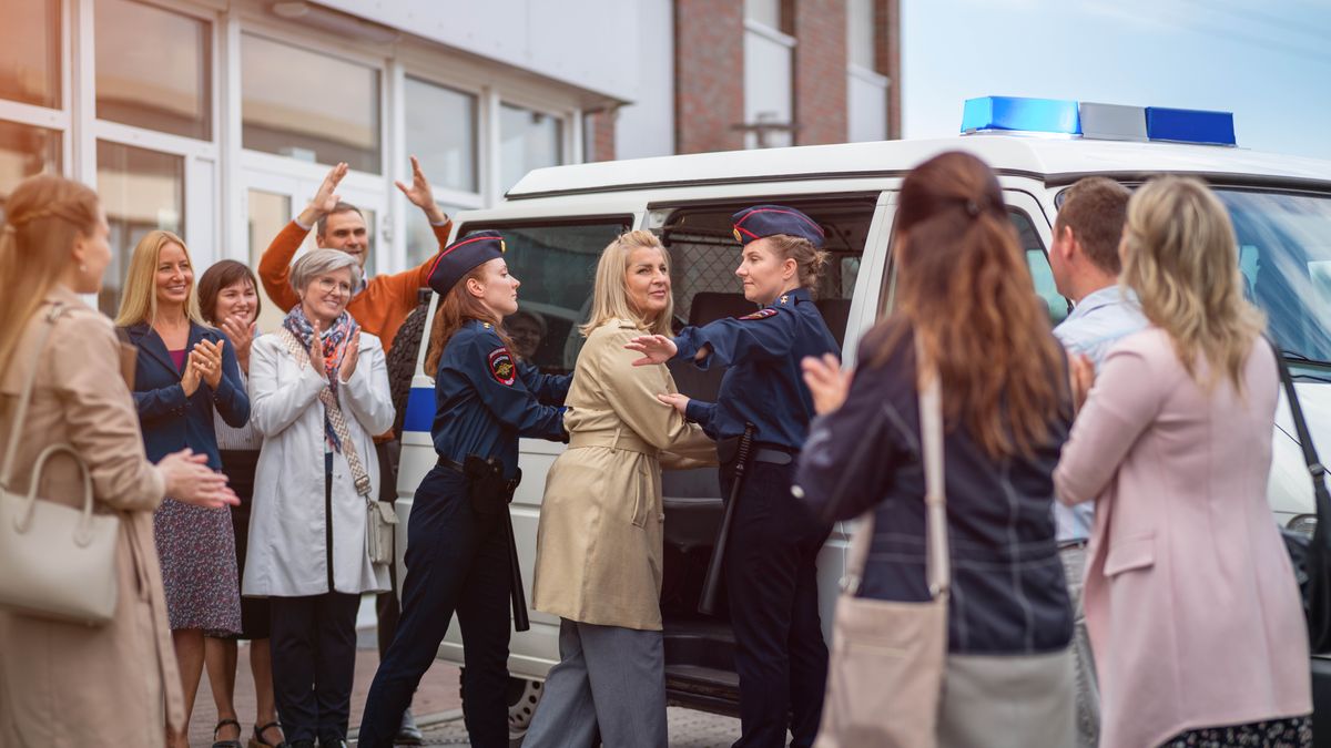 Due done polissiai le ze drio menar una sorela rento de una van. Un grupo de fradei e sorele i ze drio bater palma par ela.