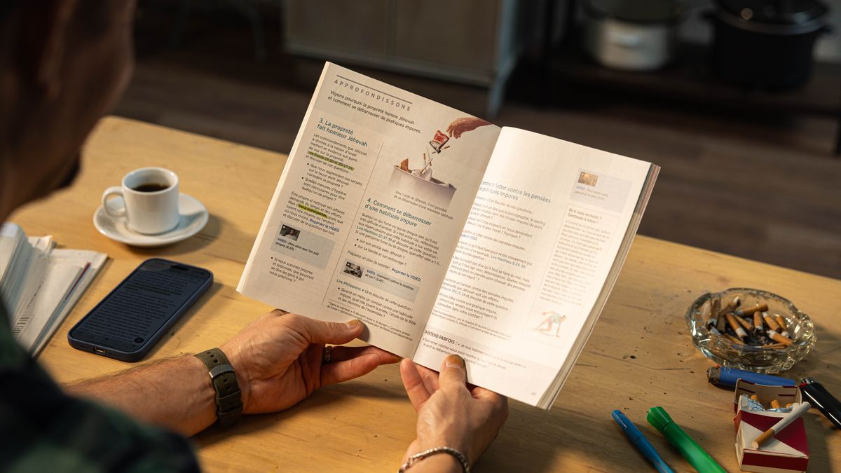 Un omo l’è drio leder la lession 40 del libro “Te pol viver felice par sempre!”. Nela so tola ghen’è una carteira de sigri e se vede che el ga fumà.