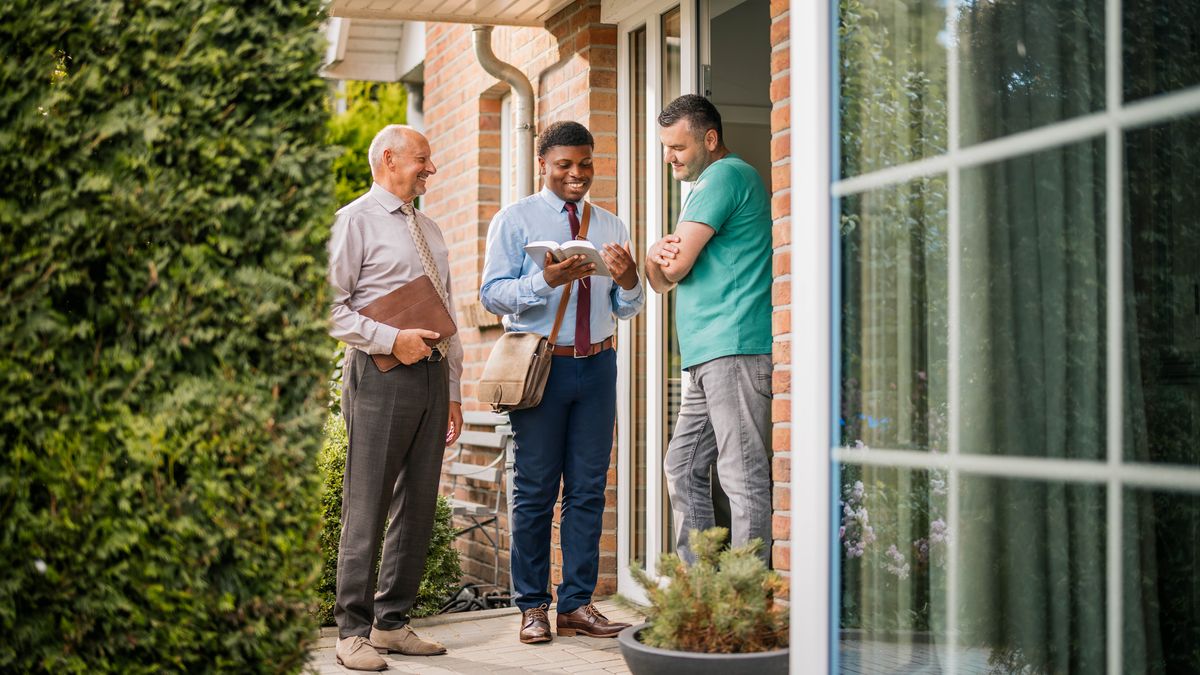 Un de quei che i ndea batesarse che ghemo visto nela stampa prima l’è drio mostrar un testo dela Bìblia a un omo che el cata nela predicassion de casa in casa.
