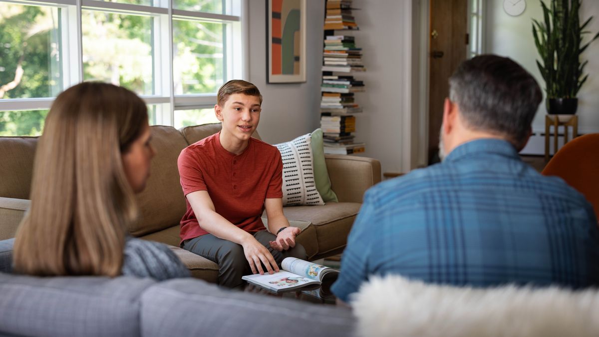 Un toso l’è drio parlar sora la lession 23 del libro “Te pol viver felice par sempre!” con so pupà e so mama.