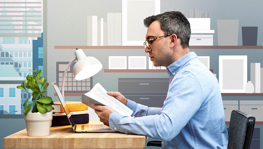 El medèsimo omo ledi la Bìblia davanti del so computador